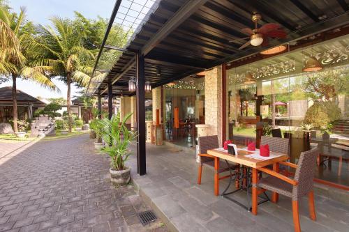a patio with a table and chairs and a building at Lumbini Luxury Villas and Spa in Jimbaran