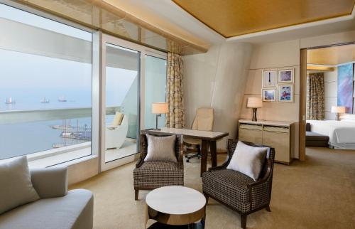 a hotel room with a bed and a table and chairs at Sheraton Huzhou Taihu Lake Hot Spring Resort & Spa in Huzhou