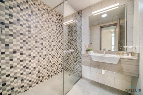 y baño con lavabo y espejo. en Pacific 1BR at Azizi Samia Jebel Ali by Deluxe Holiday Homes, en Dubái