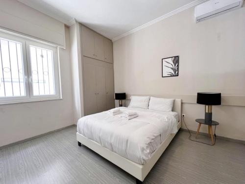 um quarto branco com uma cama e uma janela em WSD GOLDEN TIMES 8 Apartment Hotel em Atenas
