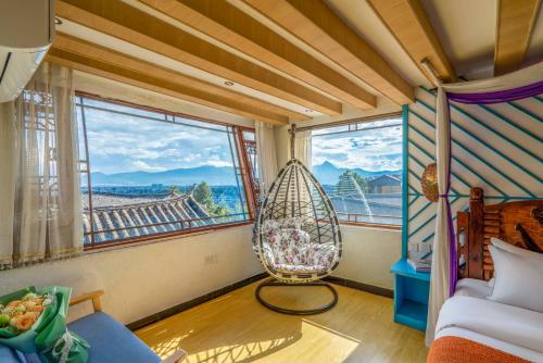 a room with a hammock in a room with windows at Frida's Inn 丽江梦之旅观景客栈 in Lijiang