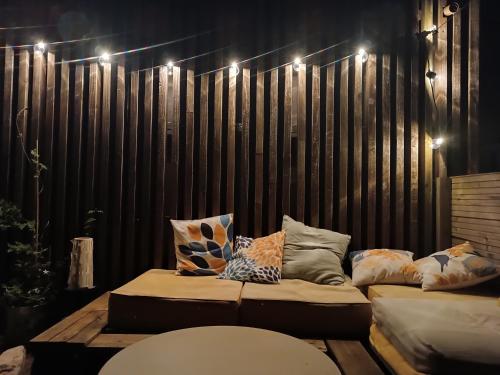 un canapé installé devant un mur en bois avec des lumières dans l'établissement Attique vue mer et campagne, la plage à pied, à Saint-Jean-de-Luz