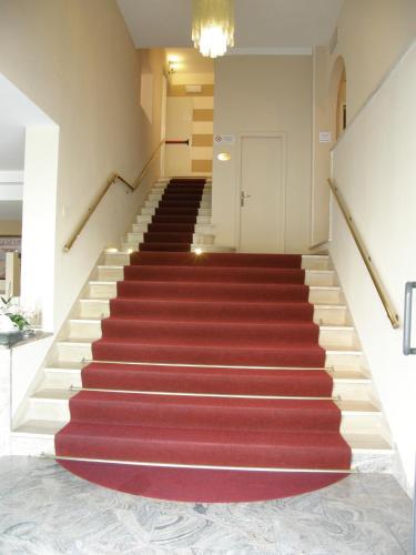 a staircase with a red carpet and a white door at Hotel Stefan Room & Breakfast in Gatteo a Mare