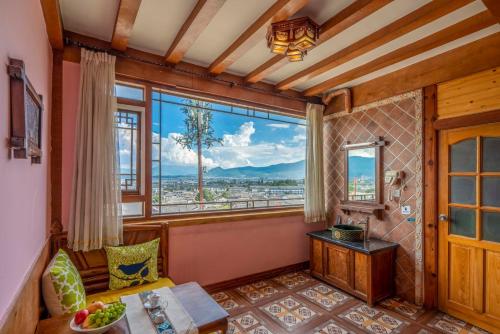 a living room with a large window and a table at Frida's Inn 丽江梦之旅观景客栈 in Lijiang