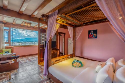 丽江Frida's Inn 丽江梦之旅观景客栈的一间带大床和大窗户的卧室