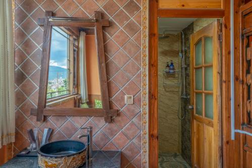 a bathroom with a mirror and a tub at Frida's Inn 丽江梦之旅观景客栈 in Lijiang