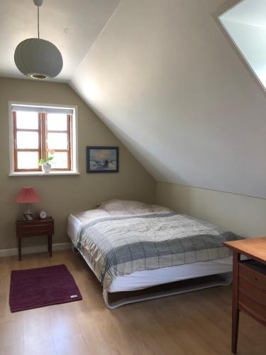 a bedroom with a bed and a window at Gården på Bakken in Holme-Olstrup