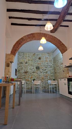 una cucina con pareti in pietra, tavoli e sedie di B&B Garibaldi ad Alcamo