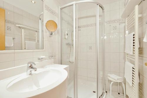 a white bathroom with a sink and a shower at Hotel St. Georg zum See in Maurach
