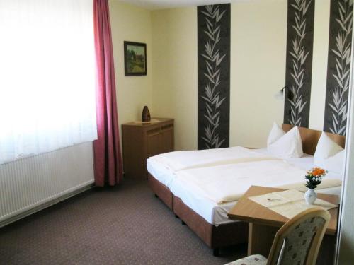 ein Hotelzimmer mit einem Bett und einem Tisch in der Unterkunft Hotel Sembziner Hof in Klink
