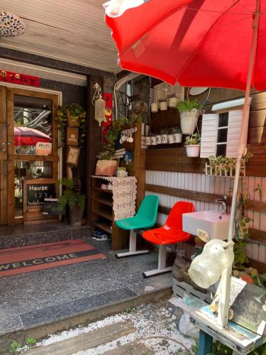 a store with a red umbrella and some chairs at House Lane 123 in Tainan