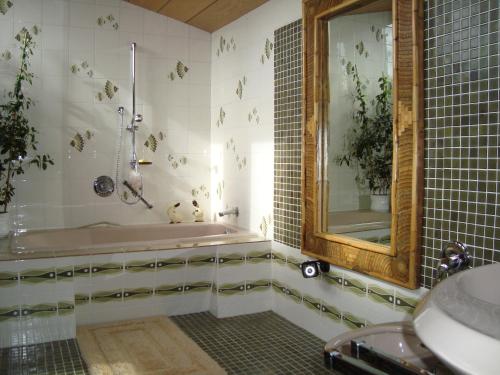 a bathroom with a tub and a mirror at Semmering Villa Sonnenschein in Semmering