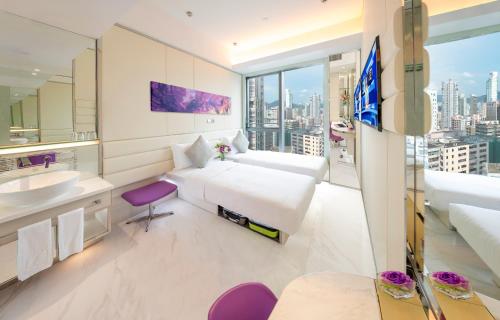 um quarto com uma cama, um lavatório e um espelho em iclub Mong Kok Hotel em Hong Kong