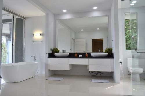 baño con 2 lavabos y espejo grande en Aroha Seaview Villa - Private Pool - en Pantai Cenang