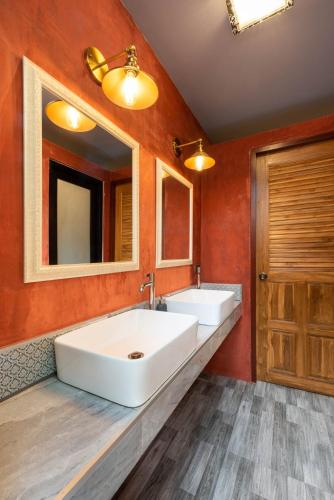 a bathroom with two sinks and a large mirror at Tepbunthom Hostel in Bangkok