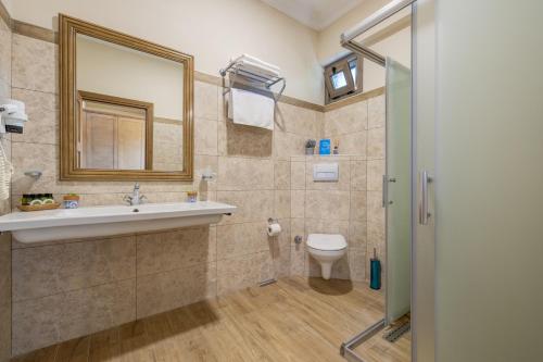 W łazience znajduje się umywalka, toaleta i lustro. w obiekcie Cinarli Kasri w mieście Gokceada