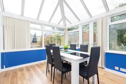 a dining room with a white table and chairs at Gorgeous Grange Fields Home - Free Parking, Self Check-in, High Speed Wi-fi, Excellent City Centre Access - Contractors Welcome in Leeds