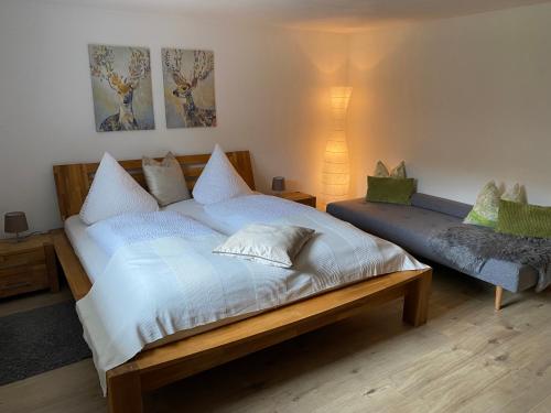 Un dormitorio con una cama grande y un banco en Appartment Kapferer en Gries im Sellrain