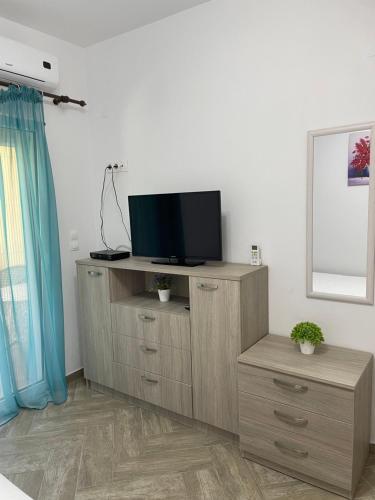 a living room with a tv on a wooden cabinet at Apartment Nikolay in Nea Potidaea