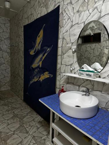 a bathroom with a sink and a mural of dolphins at Nomacurvy guest house in Roodepoort