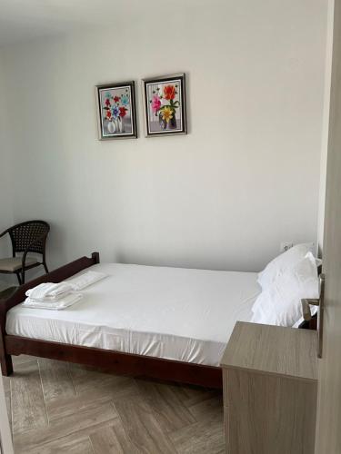 a bedroom with a bed with two pictures on the wall at Apartment Nikolay in Nea Potidaea
