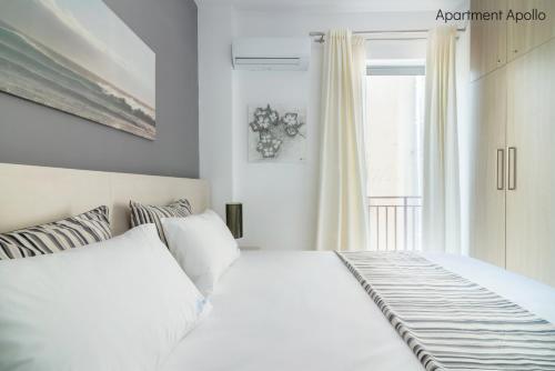 a bedroom with a white bed and a window at Apollo & Artemis by Heloni Apartments in Athens