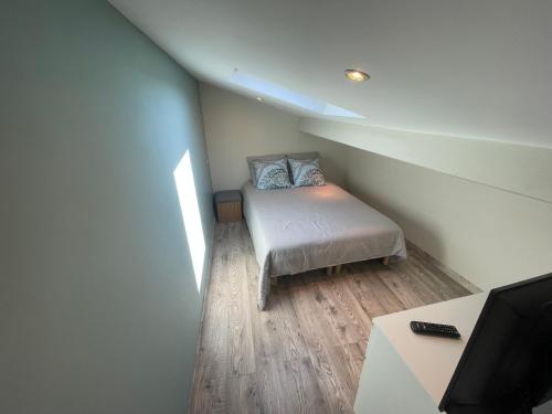 Kleines Zimmer mit einem Bett und einem TV in der Unterkunft Jolie maison avec piscine in Rochefort-du-Gard