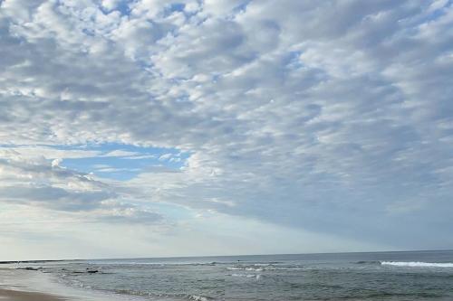 a beach with a cloudy sky and the ocean at House of Hearts in Wonthaggi