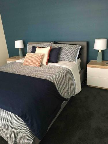 a bedroom with a bed with pillows and two lamps at House of Hearts in Wonthaggi