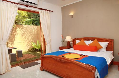 een slaapkamer met een bed en een groot raam bij Villa Velmarie Yoga and Ayurveda house all inclusive in Beruwala