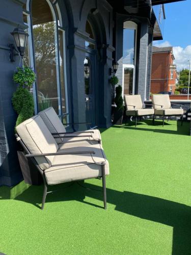 a chair sitting on a lawn on a house at The New Talbot Hotel in Southport