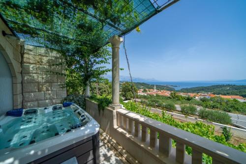a hot tub on the balcony of a house at Holiday Home Ivana in Selca