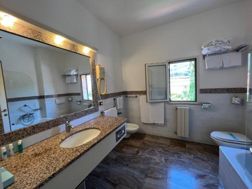 a bathroom with two sinks and a large mirror at Arthotel Gabbiano Azzurro Due in Marciana Marina