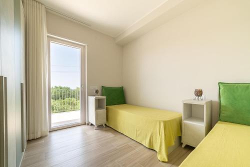 a bedroom with two beds and a window at Micabalù Luxury Apartment in Marina di Camerota