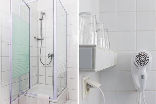 ベルリンにあるHotel Ecksteinのガラスドア付きのシャワー付きのバスルーム
