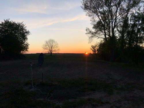 a sunset in a field with the sun setting at Landidyll in Silenz