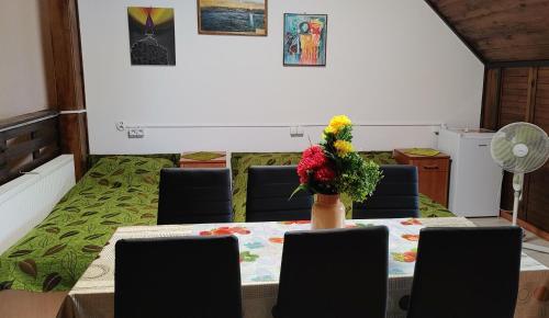 a dining room with a table with a vase of flowers on it at Suwałki Centrum Studio in Suwałki