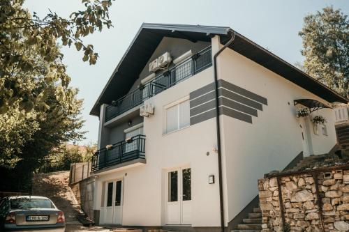 une maison blanche avec un toit noir dans l'établissement Mirna Bosna, à Sarajevo