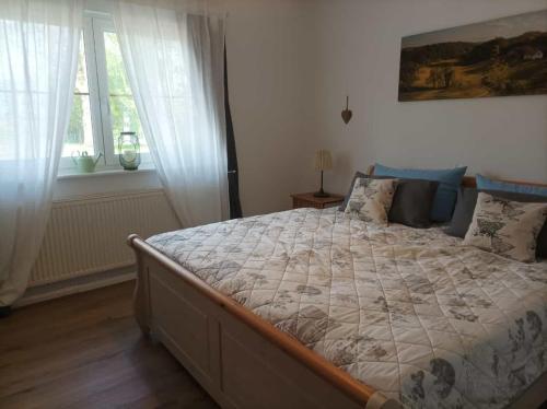 a bedroom with a large bed and two windows at Landidyll in Silenz