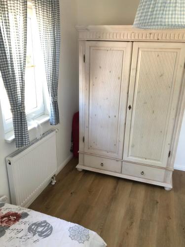 a bedroom with a white cabinet and a window at Landidyll in Silenz