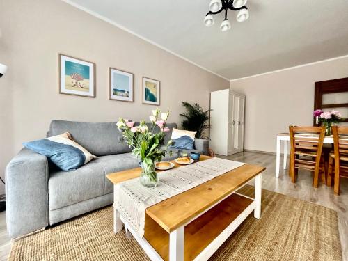 een woonkamer met een bank en een tafel bij Apartament Sea Nest Brzeźno, blisko morza in Gdańsk