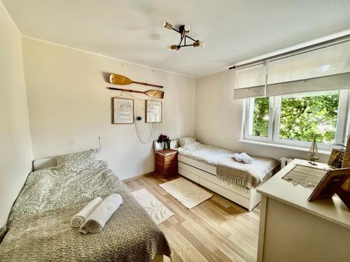 een kleine slaapkamer met twee bedden en een raam bij Apartament Sea Nest Brzeźno, blisko morza in Gdańsk