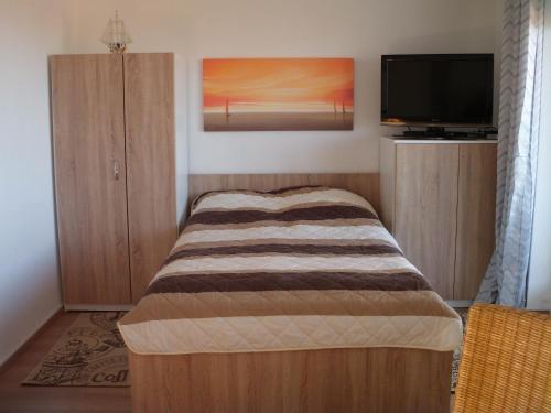 a bedroom with a bed and a flat screen tv at Tief 10 Wohnung 408 in Wangerland