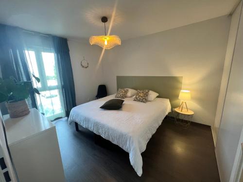- une chambre avec un lit et un lustre dans l'établissement T2 cosy Ajaccio, à Ajaccio
