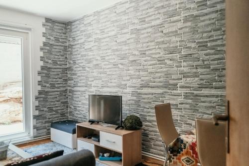 un salon avec un mur en brique ; dans l'établissement Mirna Bosna, à Sarajevo
