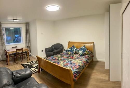 a bedroom with a bed and a couch and a table at King Studio Apartment with Garden and Parking in Ealing