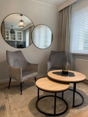 sala de estar con mesa, 2 sillas y espejo en Loft Sopot, en Sopot