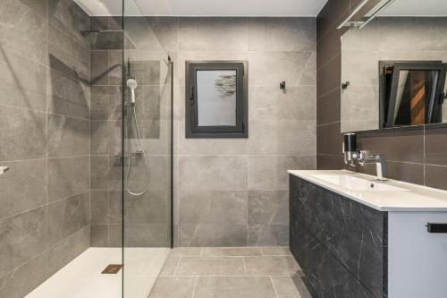 een badkamer met een douche en een wastafel bij Villa Welcs EMP 083 con piscina infinita in Roses