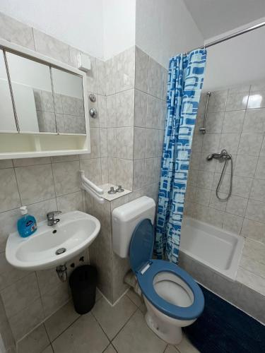 a bathroom with a toilet and a sink and a shower at Central Studio Apartments & Dormitory Rooms in Supetar