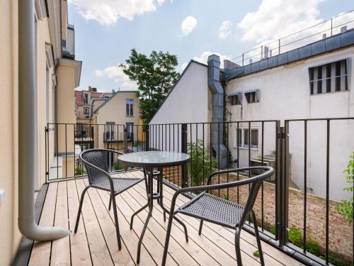 um pátio com 2 cadeiras e uma mesa na varanda em MySchönbrunn Apartments em Viena